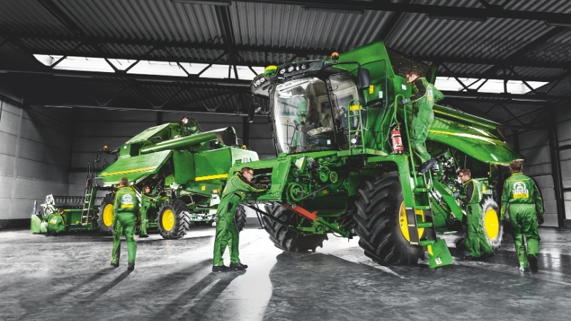 Équipe de techniciens HAAG réalisant un contrôle Expert Check sur une moissonneuse-batteuse John Deere dans un atelier