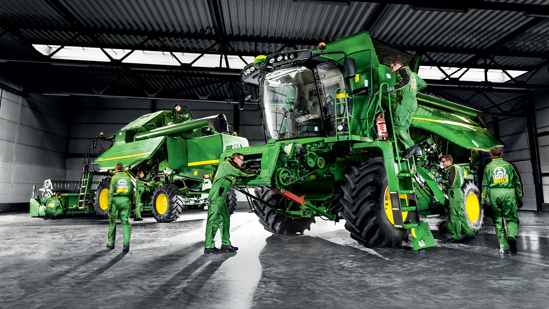 Équipe de techniciens HAAG réalisant un contrôle Expert Check sur une moissonneuse-batteuse John Deere dans un atelier