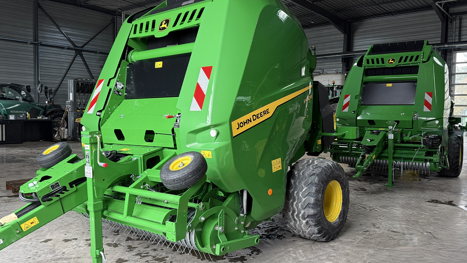Presses à balles rondes John Deere vertes dans l'atelier HAAG prêtes pour la maintenance avant la saison de pressage