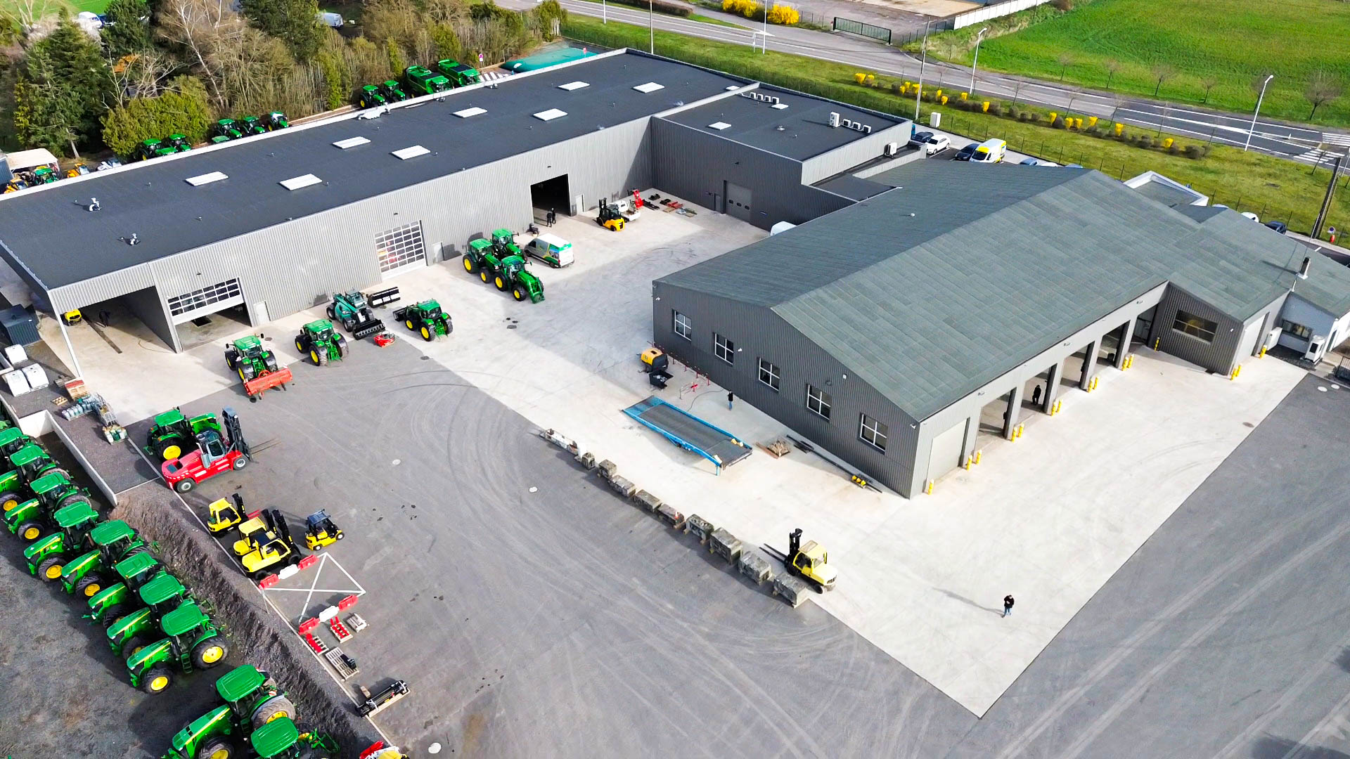 Vue aérienne du parc de matériels agricoles HAAG à Azerailles, avec tracteurs John Deere alignés et bâtiments de l'agence
